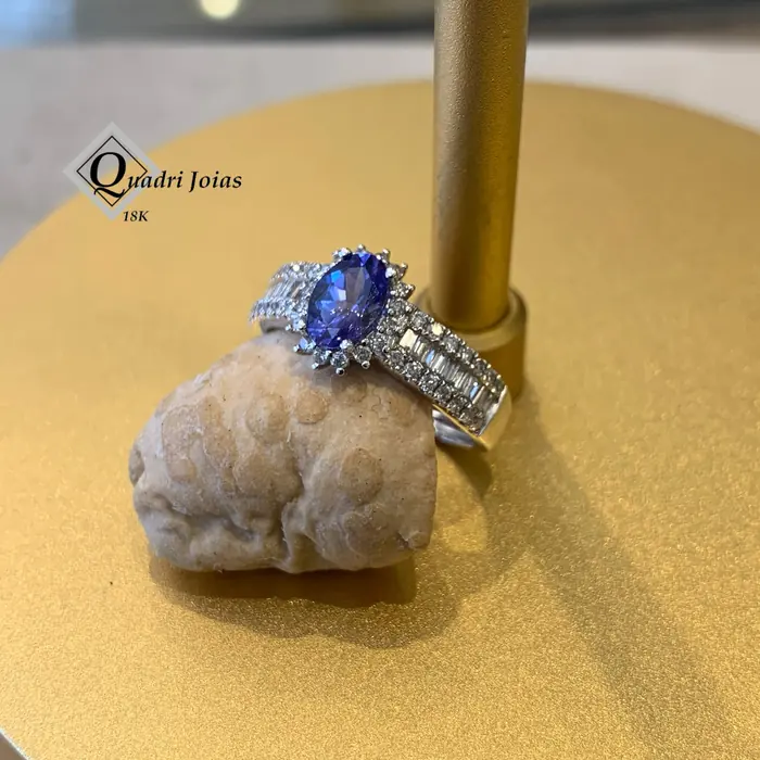 Anel com tanzanita oval cercada de diamantes redondos e baguetes