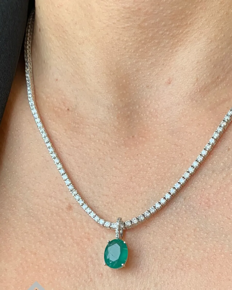 Colar riviera de diamantes com pingente de esmeralda no colo