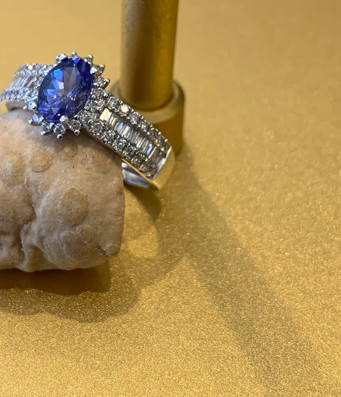 Anel de tanzanita e diamantes em expositor dourado